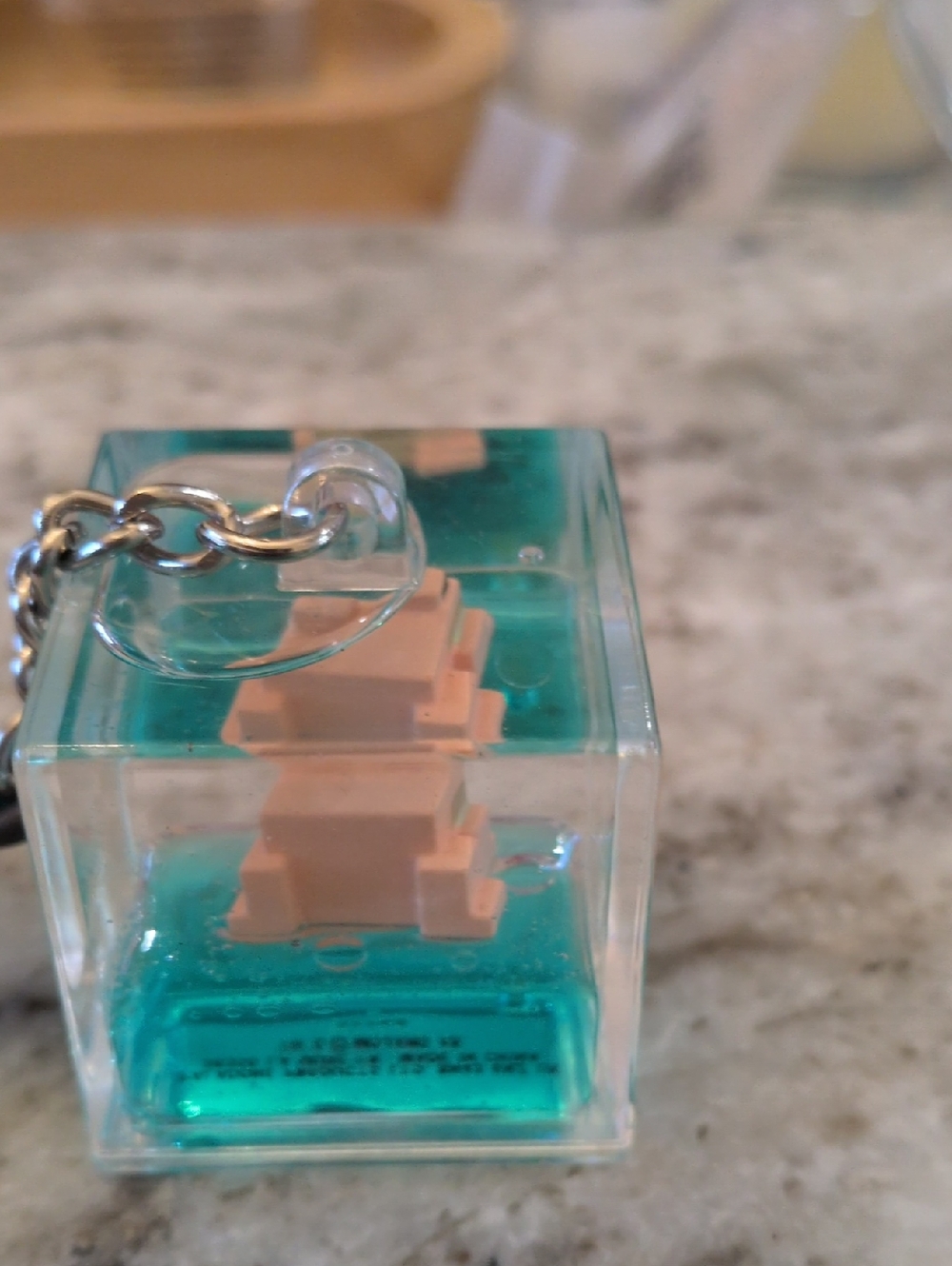 Clear Acrylic Teal Cube Keychain with Beige Figure